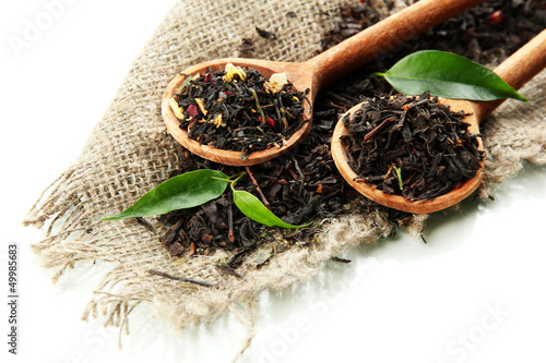 Plakat na zamówienie Dry tea with green leaves in wooden spoons, isolated on white