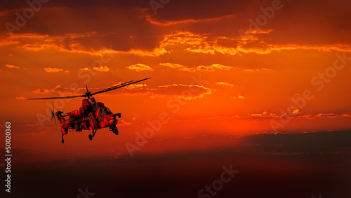 Fotoboard na płycie Wojskowy helikopter w locie przed dramatycznym czerwonym niebie