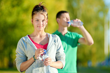 Man and woman drinking from bottle