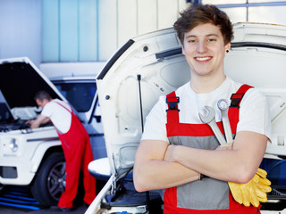 Apprentices for car mechanic is satisfied with his job