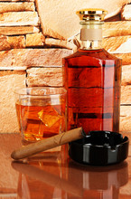 Bottle And Glass Of Whiskey And Cigar On Brick Wall Background