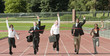© Pete Saloutos/Blend Images - Business people running across track finish line