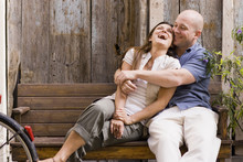 Laughing Couple Hugging On Bench