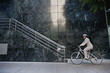 © Peathegee Inc/Blend Images - Businesswoman riding bicycle on sidewalk