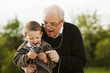 © Mike Kemp/Blend Images - Caucasian grandfather and grandson listening to mp3 player