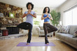 © Peathegee Inc/Blend Images - Couple practicing yoga in living room