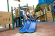 © Jihan Abdalla/Blend Images - Family sliding down slide on playground