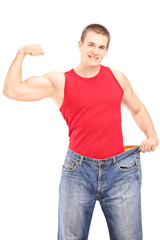 Sticker - Weight loss man showing his muscles and holding an old pair of j