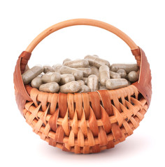 Wall Mural - Herbal drug capsules in wicker basket. Alternative medicine conc