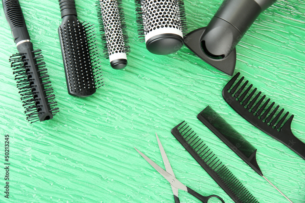 Comb brushes, hairdryer and cutting shears,on color background