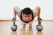 © pio3 - Young man training in the gym with heavy balls.