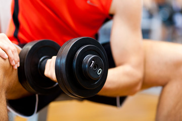 Young athlete lifting weights in the gym