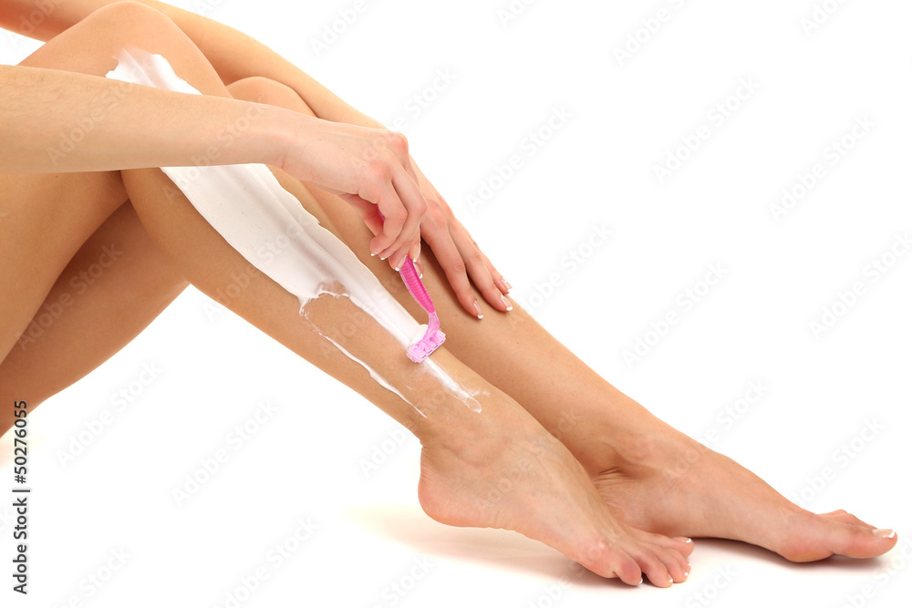 Beautiful woman is shaving her leg, isolated on white
