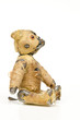 antiker abgenutzter Teddybär,seitlich sitzend