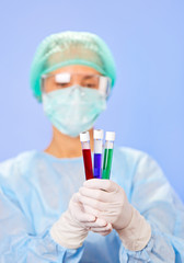 Wall Mural - Medical test tube samples in doctor's hand on blue background