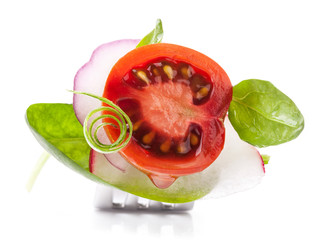 Poster - Tomato slice and leaf of spinach on fork isolated on white