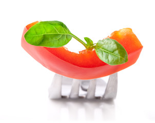 Wall Mural - Bell pepper slice and leaf of spinach on fork isolated on white 