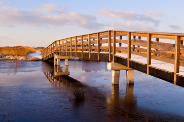 Fototapete - wooden bridge through frozen river