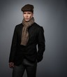 © Nejron Photo - Young man in brown jacket wearing cap and scarf isolated on grey