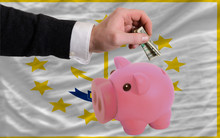 Dollar Into Piggy Rich Bank And  Flag Of American State Of Rhode