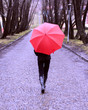 Girl with red umbrella walking away