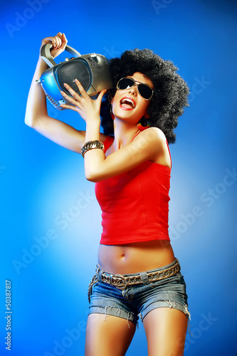Poster Happy tanned woman enjoying music holding tape recorder.