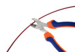 Metal nippers is cutting red cable on white background