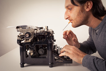 man thinking at typewriter