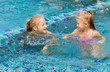 © altanaka - two happy little girls splashing around in the pool