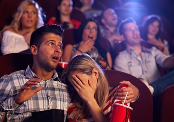 Wall Mural - Young couple watching horror in movie theater