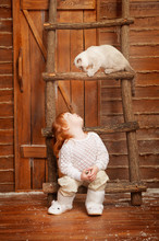 Little Girl With A Cat On A Porch