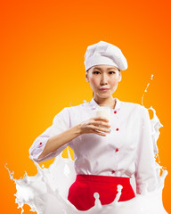 Asian female cook against milk splashes