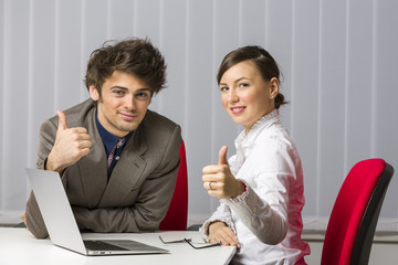 Cheerful successful business team giving the thumbs up