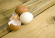 dwa jajka i skorupka na drewnianym stole