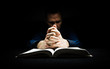 © Duncan Andison - Man praying to God with his hands resting on a bible.