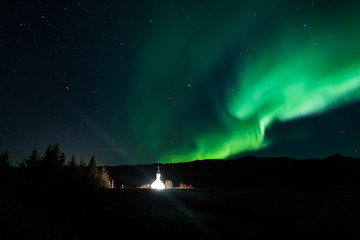 Wall Mural - northern lights above a church in iceland