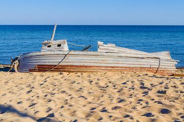 old wooden fishing boat  lying on a seashore