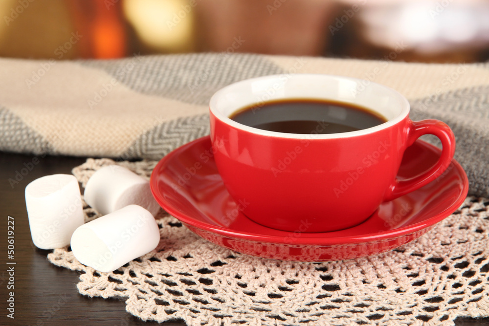 cup of coffee with scarf on table in room