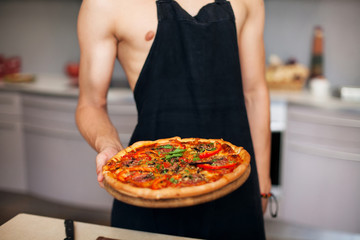 Pizza  sexy chef holding pizza on wooden plate