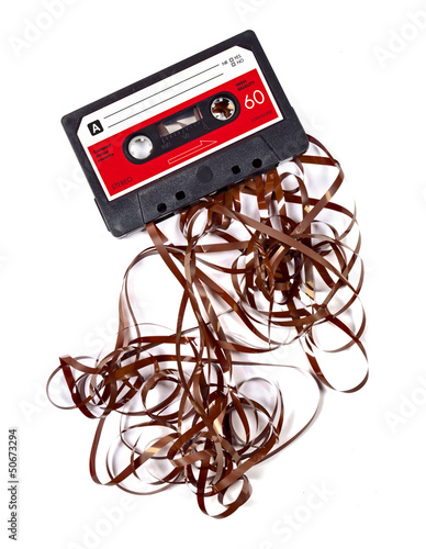 Fototapeta na wymiar Old worn down eighties cassette with band pulled out