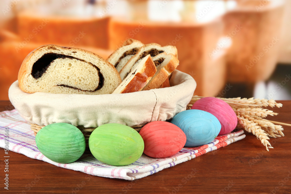 Loaf with poppy seed in wicker basket, on bright background