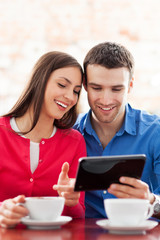 Poster - Couple using digital tablet in cafe