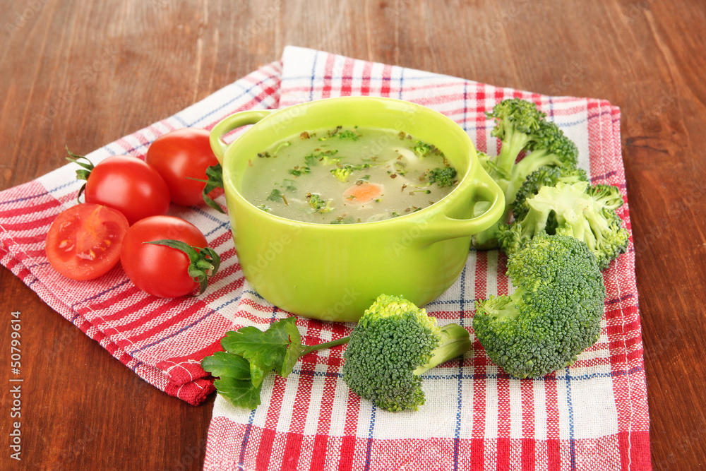 Diet soup with vegetables in pan on wooden table close-up