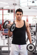 © pio3 - Young man exercising with dumbbells in a gym.