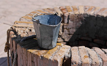 A Water Well With An Old Bucket
