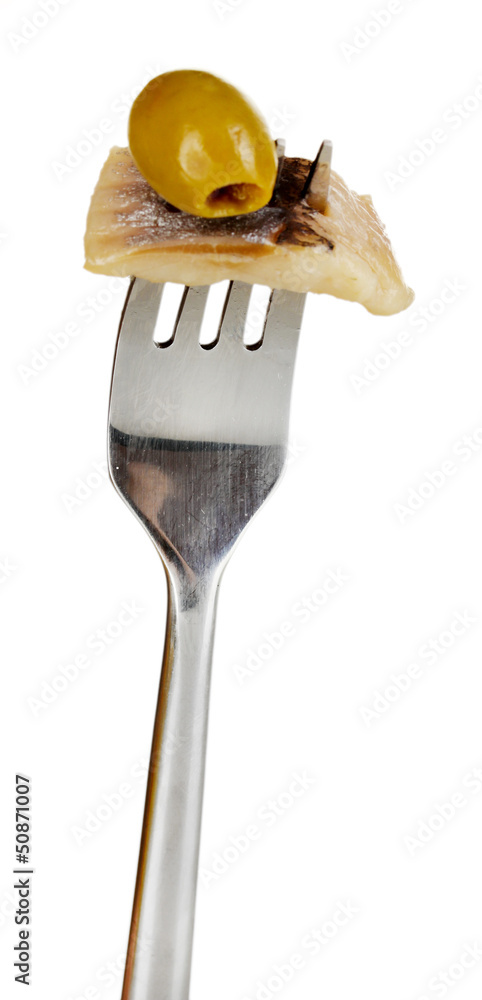 Piece of herring and olive on fork isolated on white