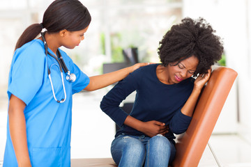 Wall Mural - young african nurse comforting female patient