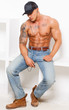 Tired sexy guy in jeans and boots is listening music