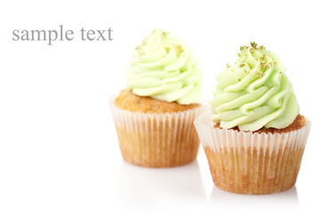 Wall Mural - two cupcakes with green cream isolated on white background with