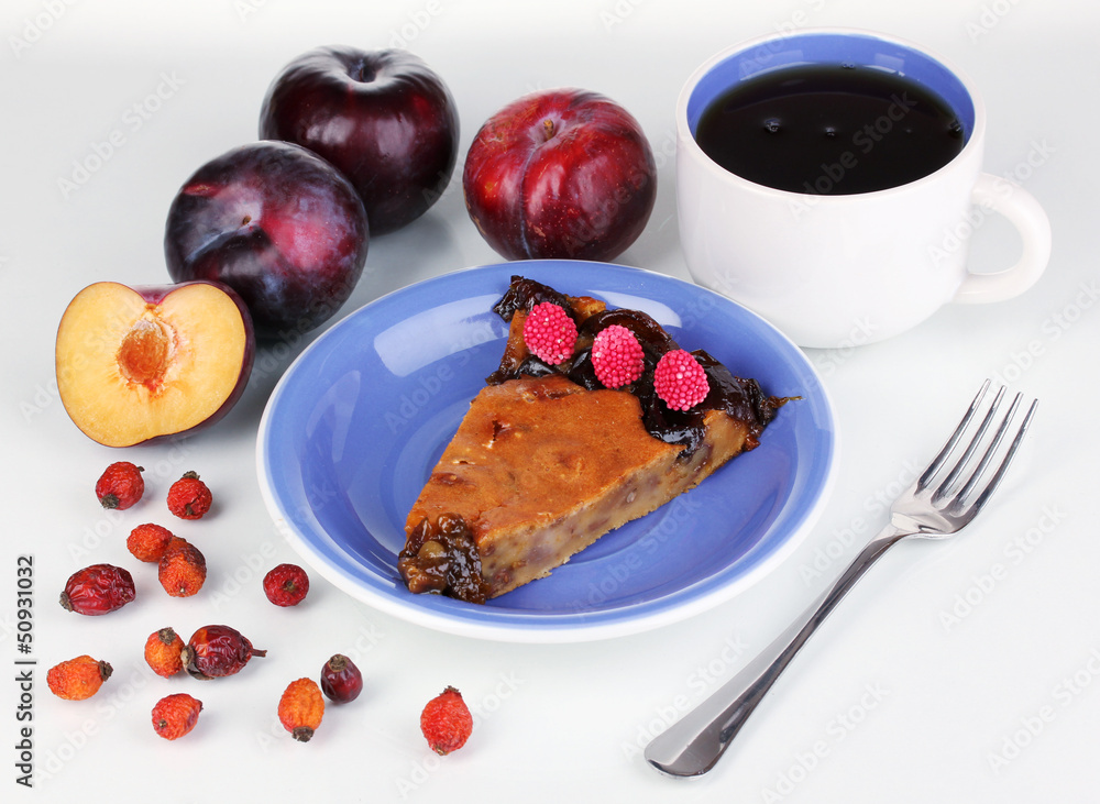 Tasty pie on blue plate with plums isolated on white